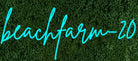 beachfarm-20 custom LED neon sign in cyan script on a green hedge